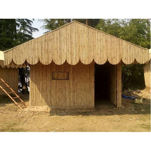 Home 1 A small outdoor bamboo huts structure with gabled roof and walls made of vertical bamboo poles, featuring a scalloped edge along the roofline.